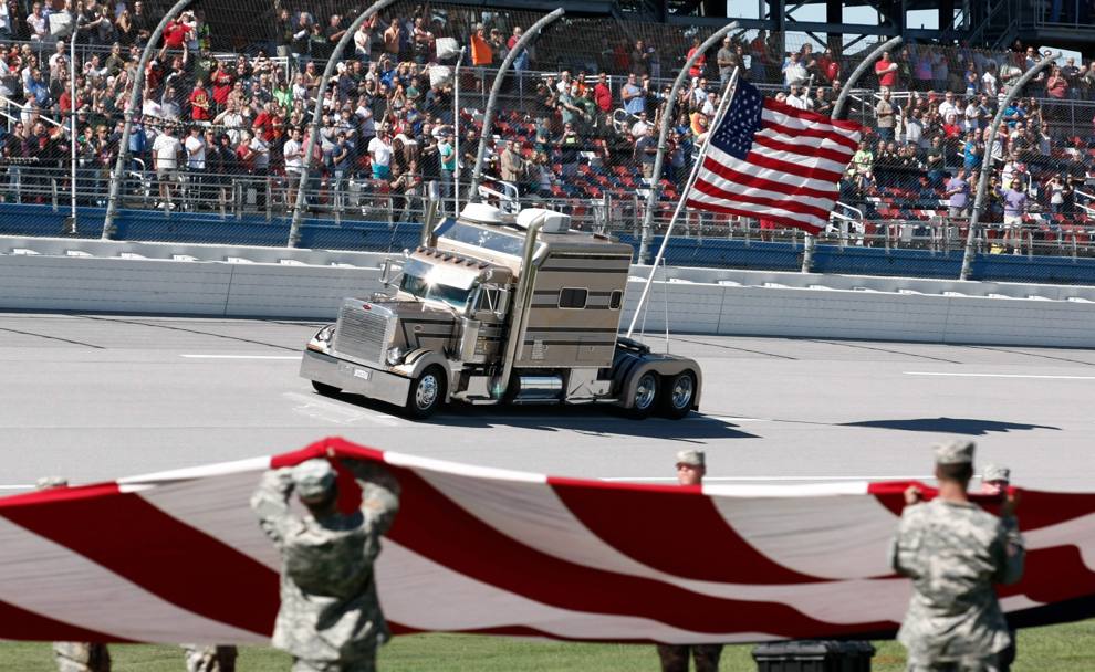 Un gigantesco camion porta la bandiera americana durante l’inno prima della gara del campionato Nascar sul circuito di Talladega Superspeedway (REUTERS)